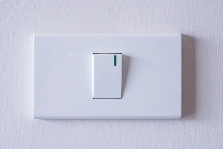 White toggle light switch on a wall, representing residential electrical options and installation services by Kazar’s Electric.